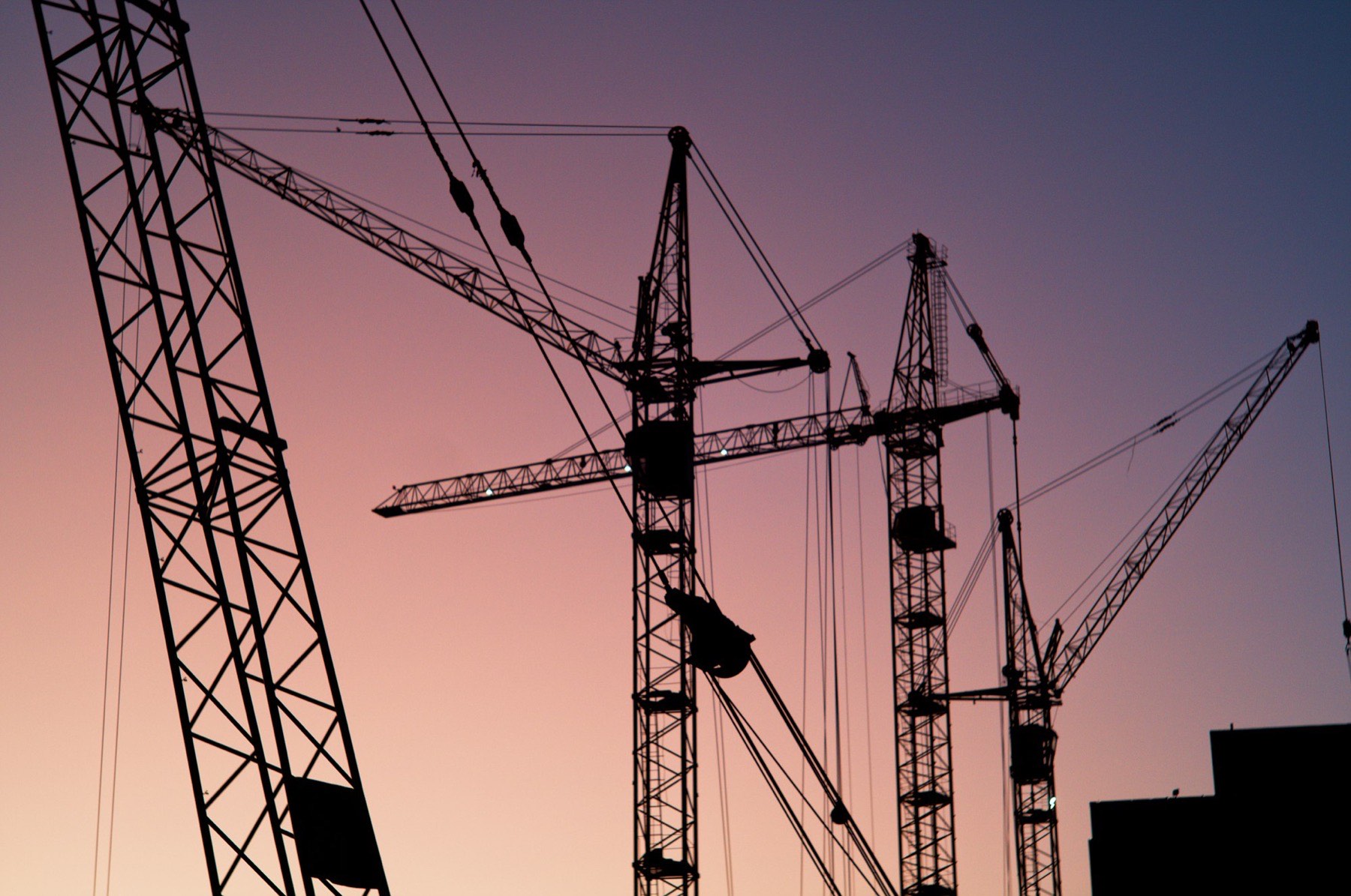 Cranes setting prefabricated modules at dusk